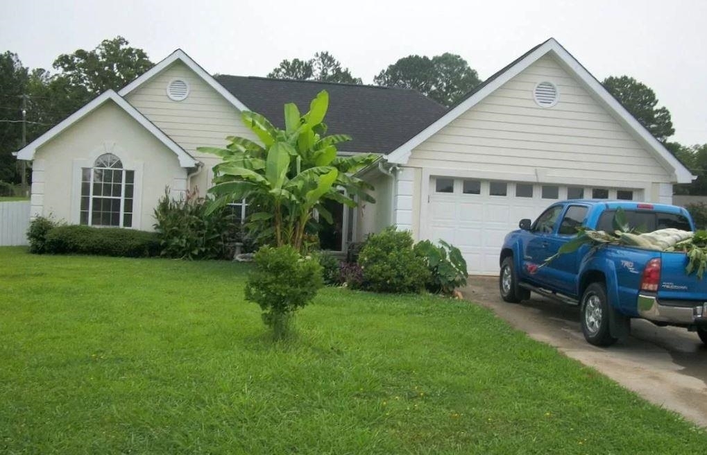 a front view of house with a garden