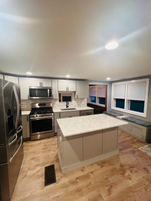 a large white kitchen with a stove a sink and a refrigerator