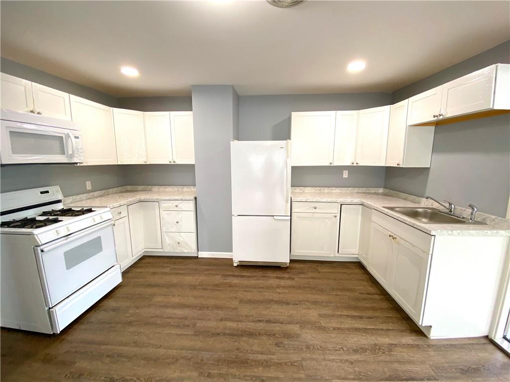 a kitchen with granite countertop white cabinets and white appliances