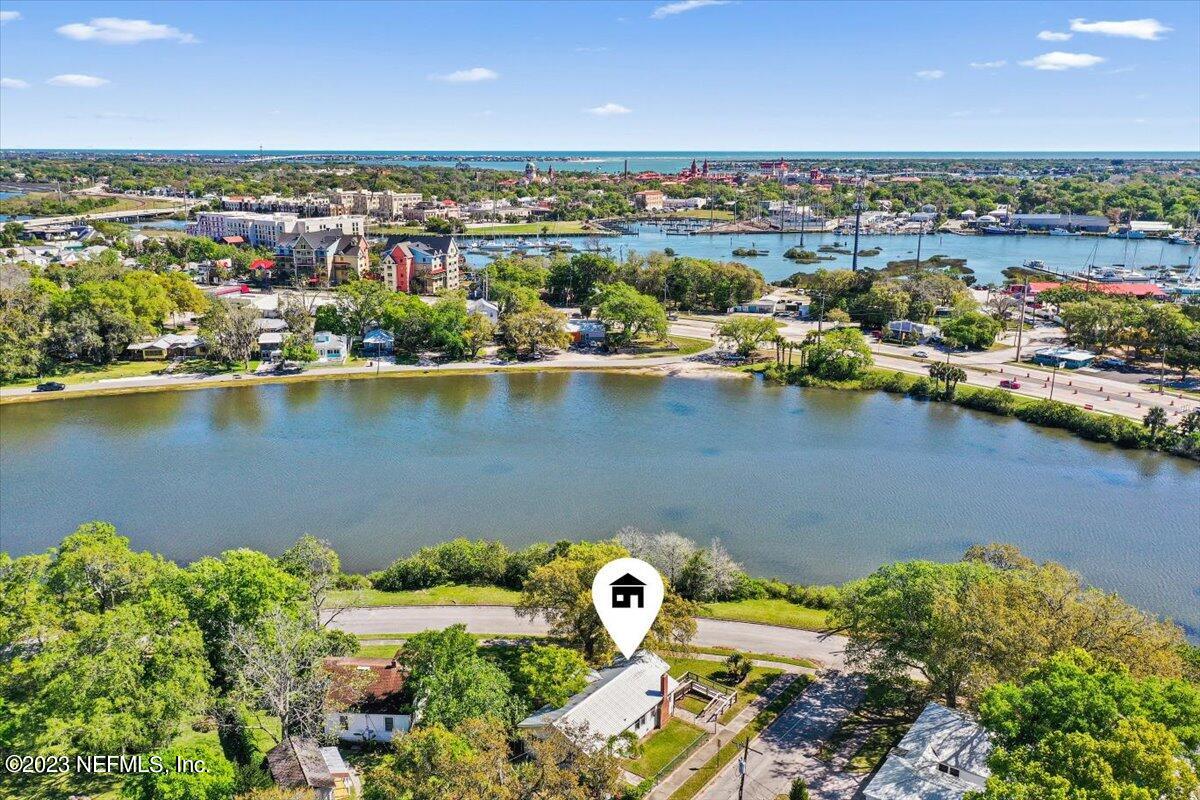 an aerial view of residential houses with outdoor space and lake view