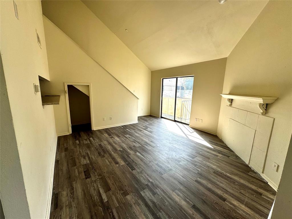 a view of a room with wooden floor and a window