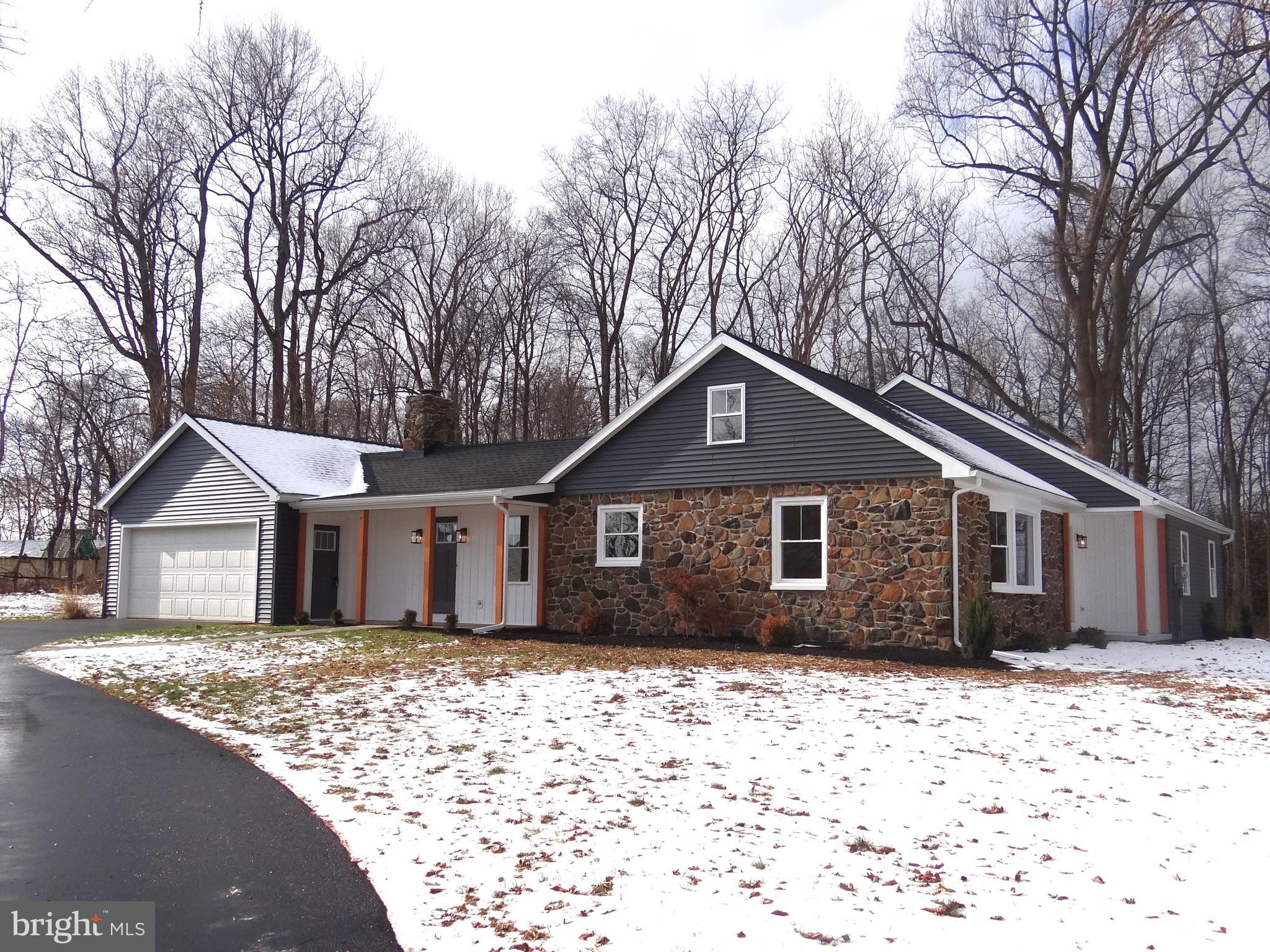 a front view of a house with a yard covered in snow