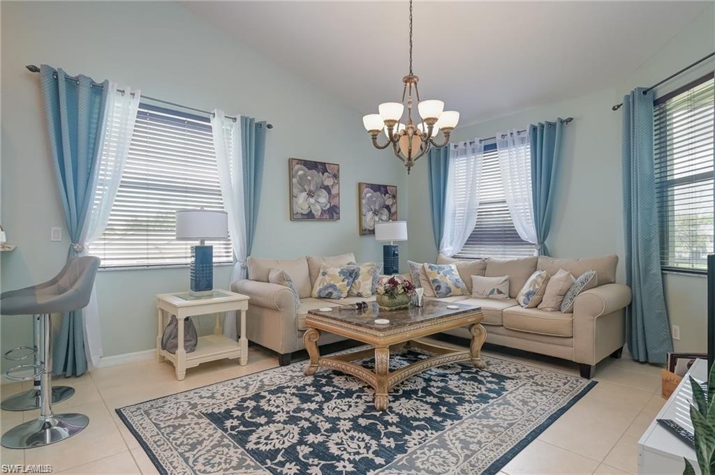 a living room with a couch chandelier and a window