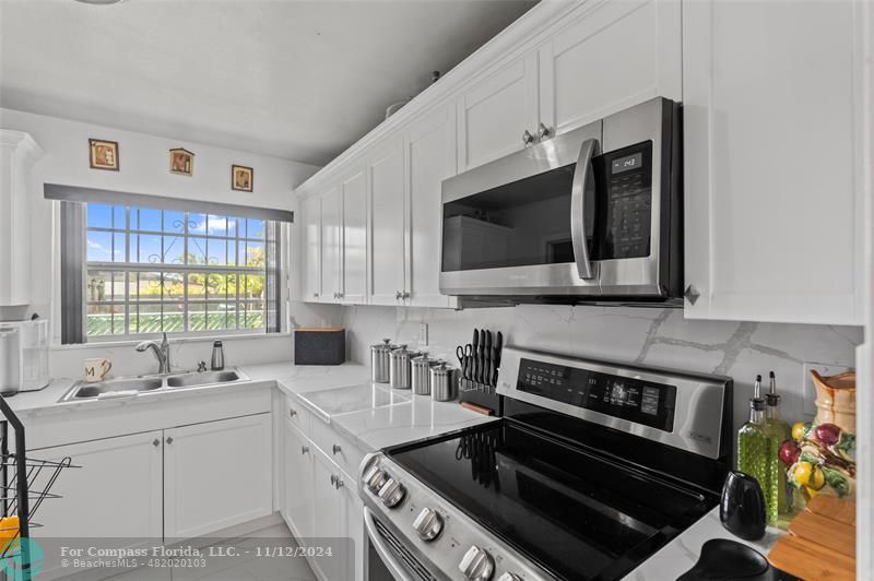 a kitchen with stainless steel appliances a sink stove and microwave