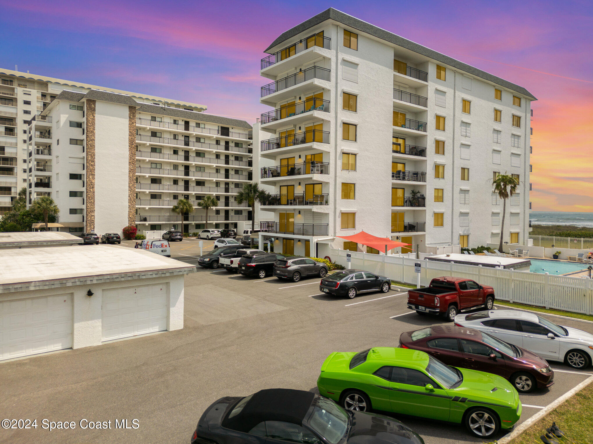 a front view of a building with cars parked