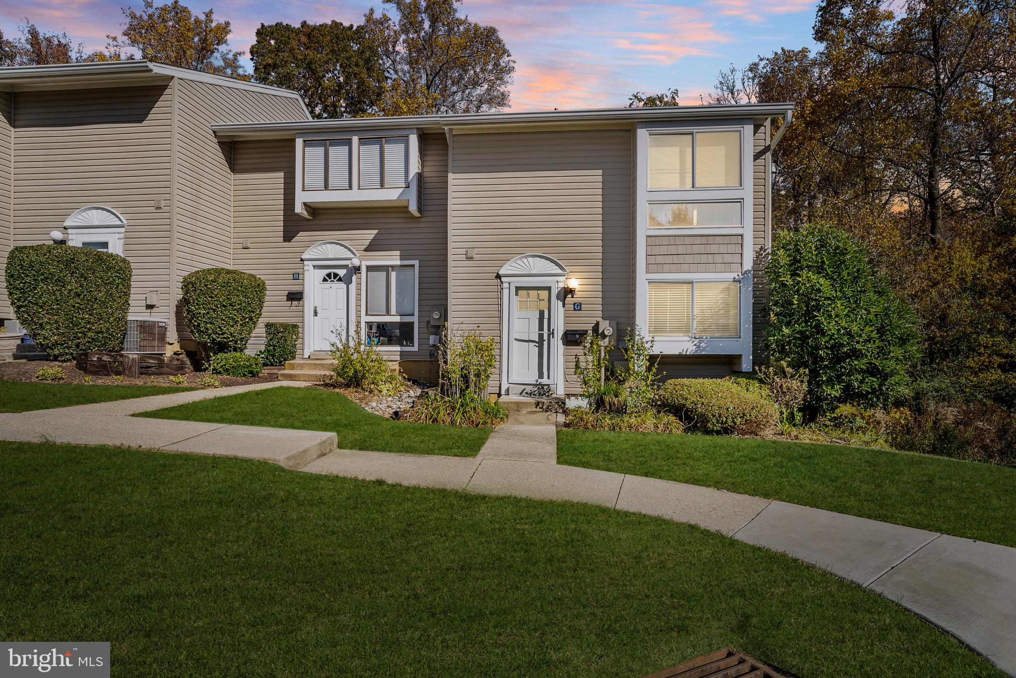 a front view of a house with a garden and plants