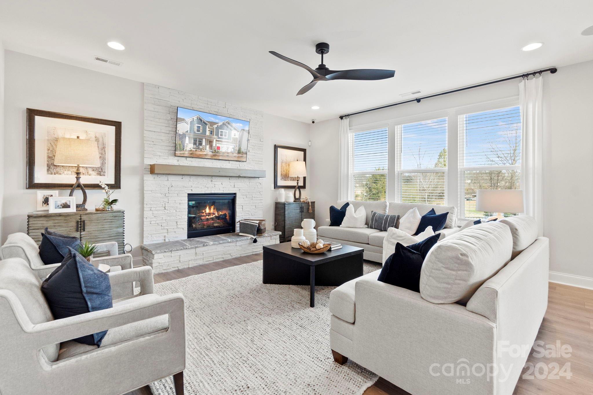 a living room with furniture a large window and a fireplace