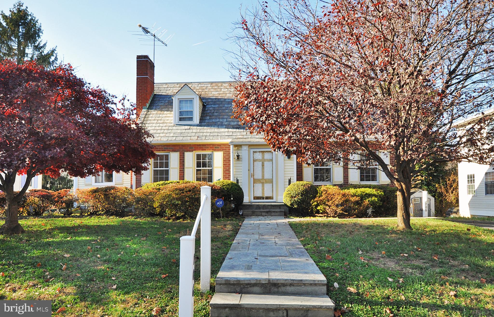 a front view of a house with a yard and trees