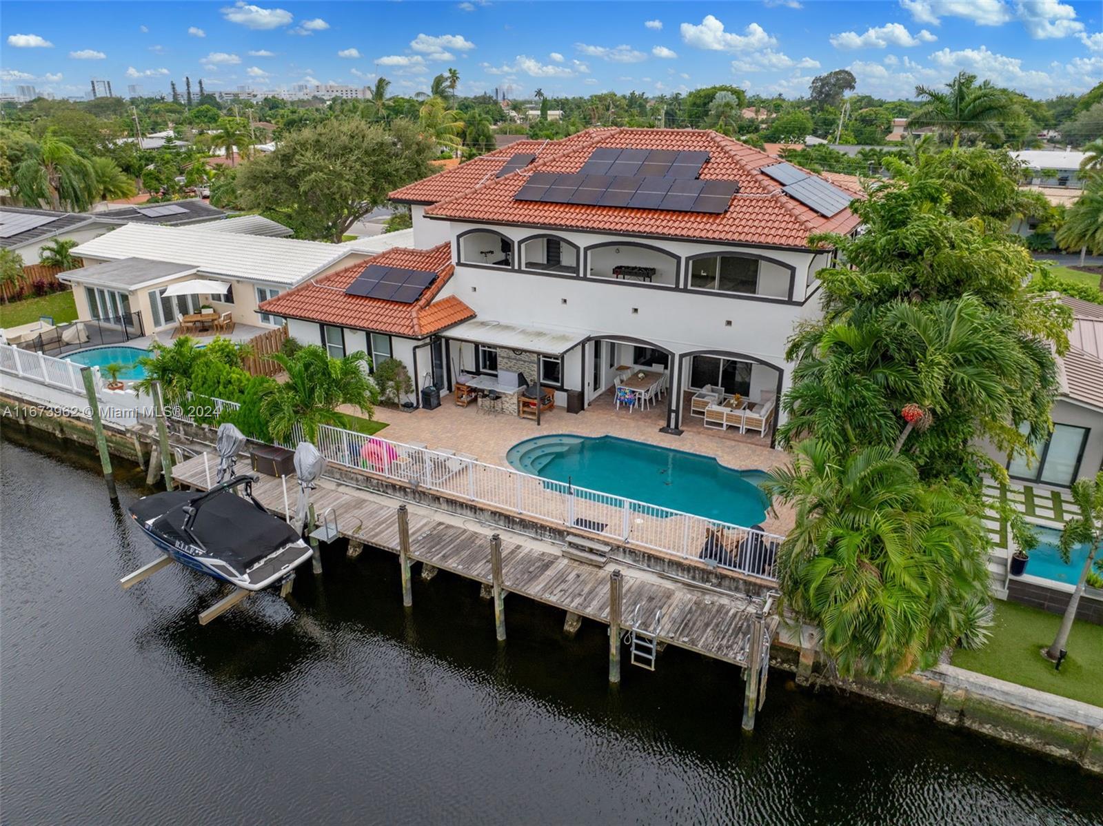 an aerial view of a house with swimming pool and a yard