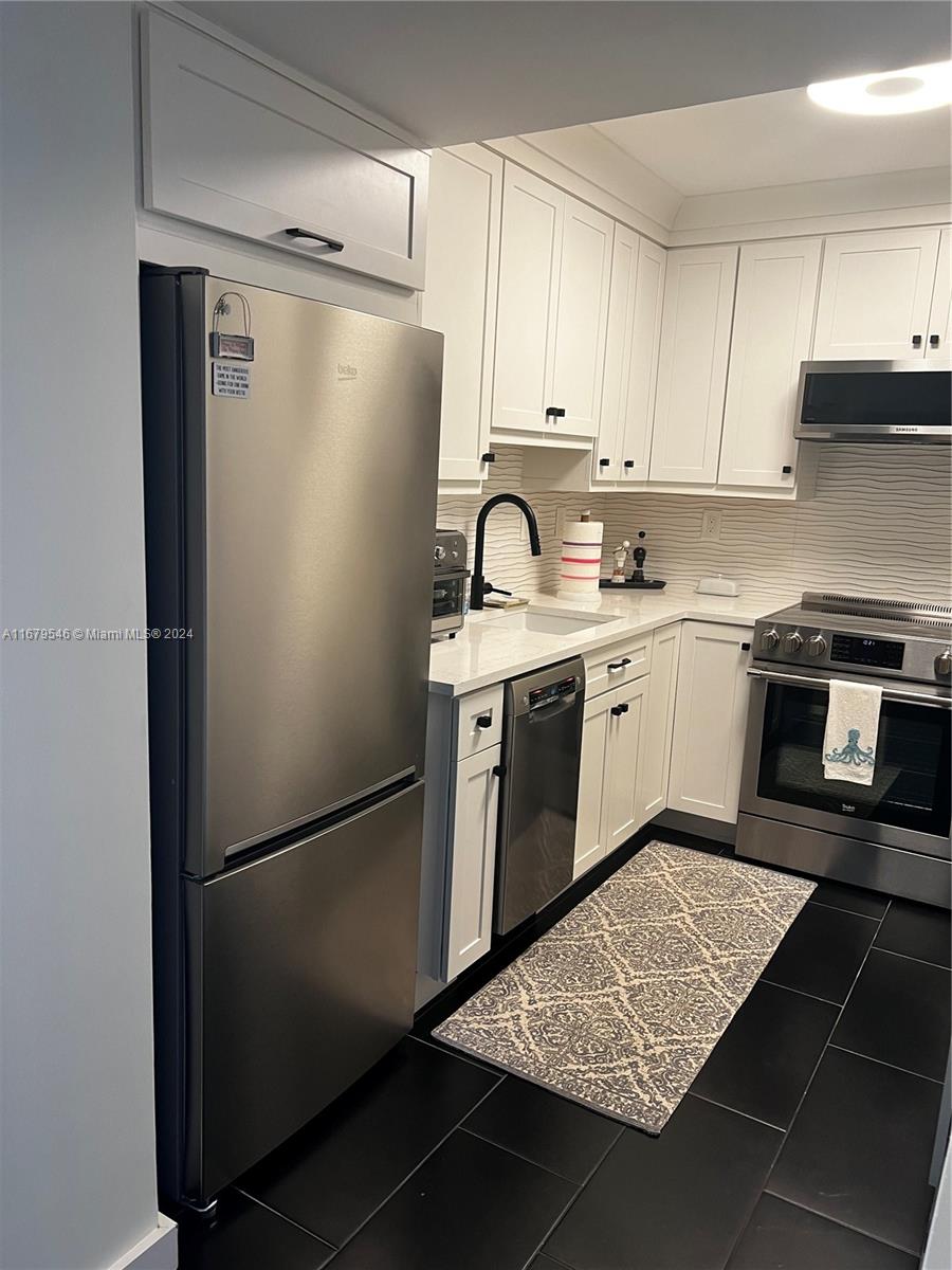 a kitchen with stainless steel appliances granite countertop a refrigerator sink and cabinets