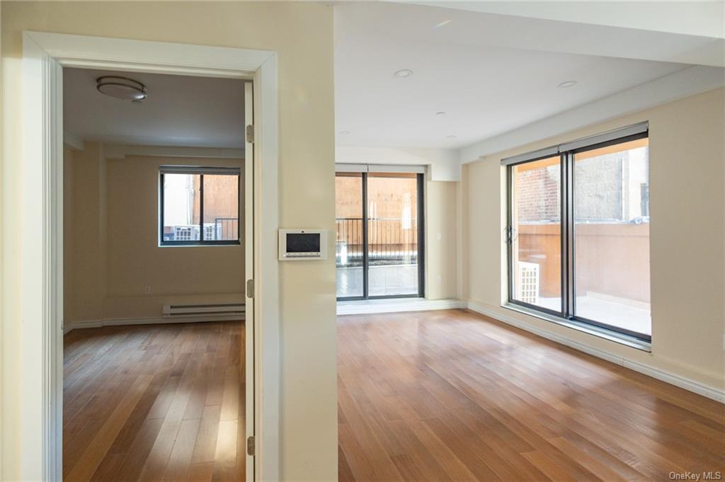 Spare room featuring a wealth of natural light, a baseboard radiator, and light wood-type flooring