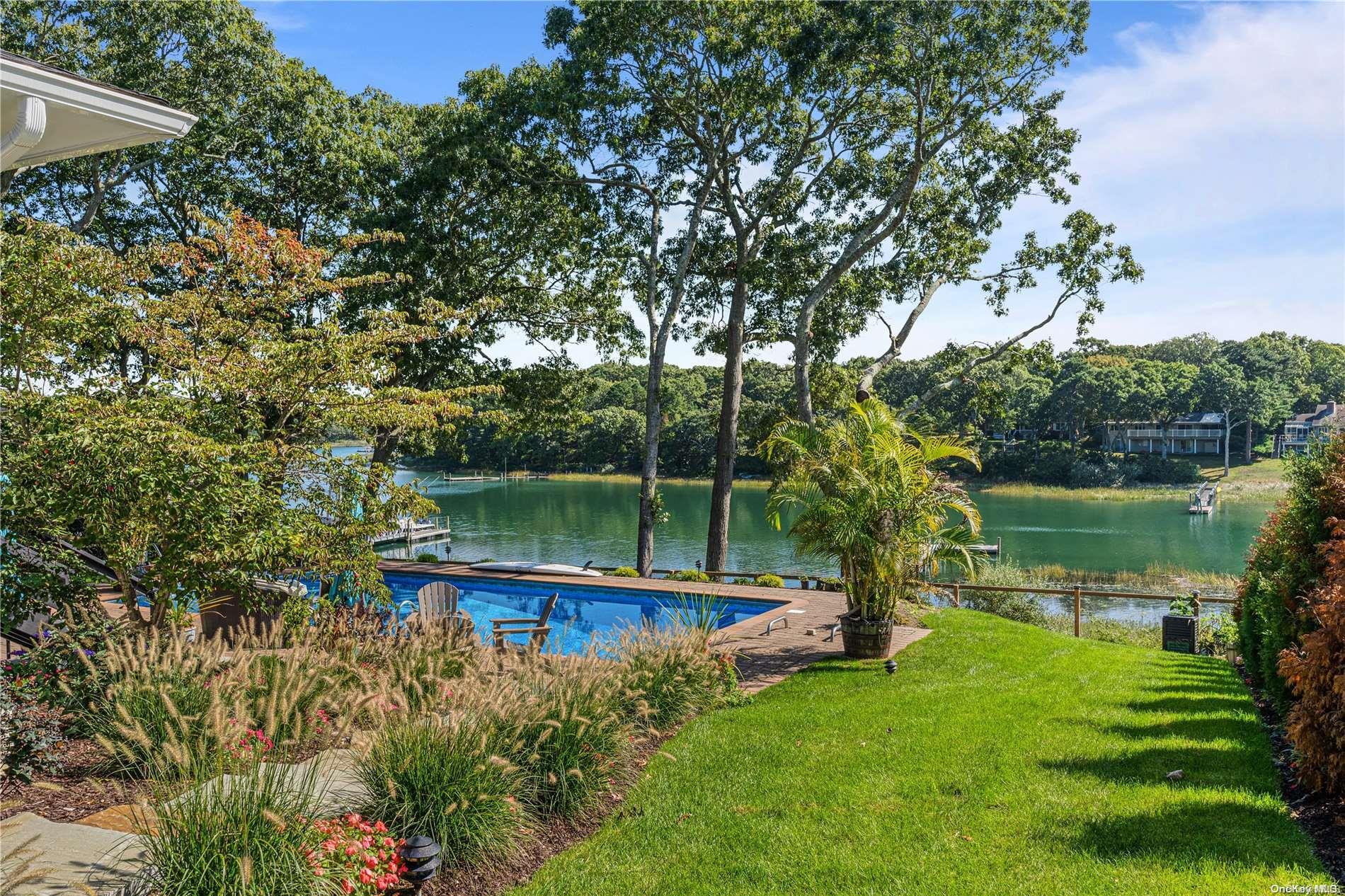 a view of a lake with a yard and outdoor seating