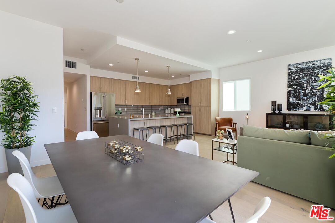 a living room with furniture and a dining table with kitchen view