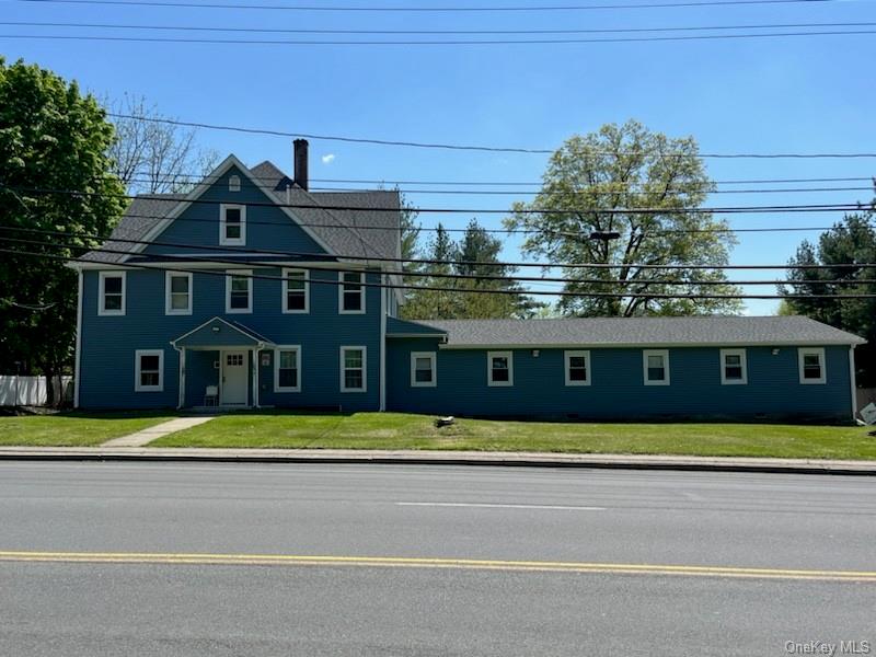 a front view of a house with a yard and trees