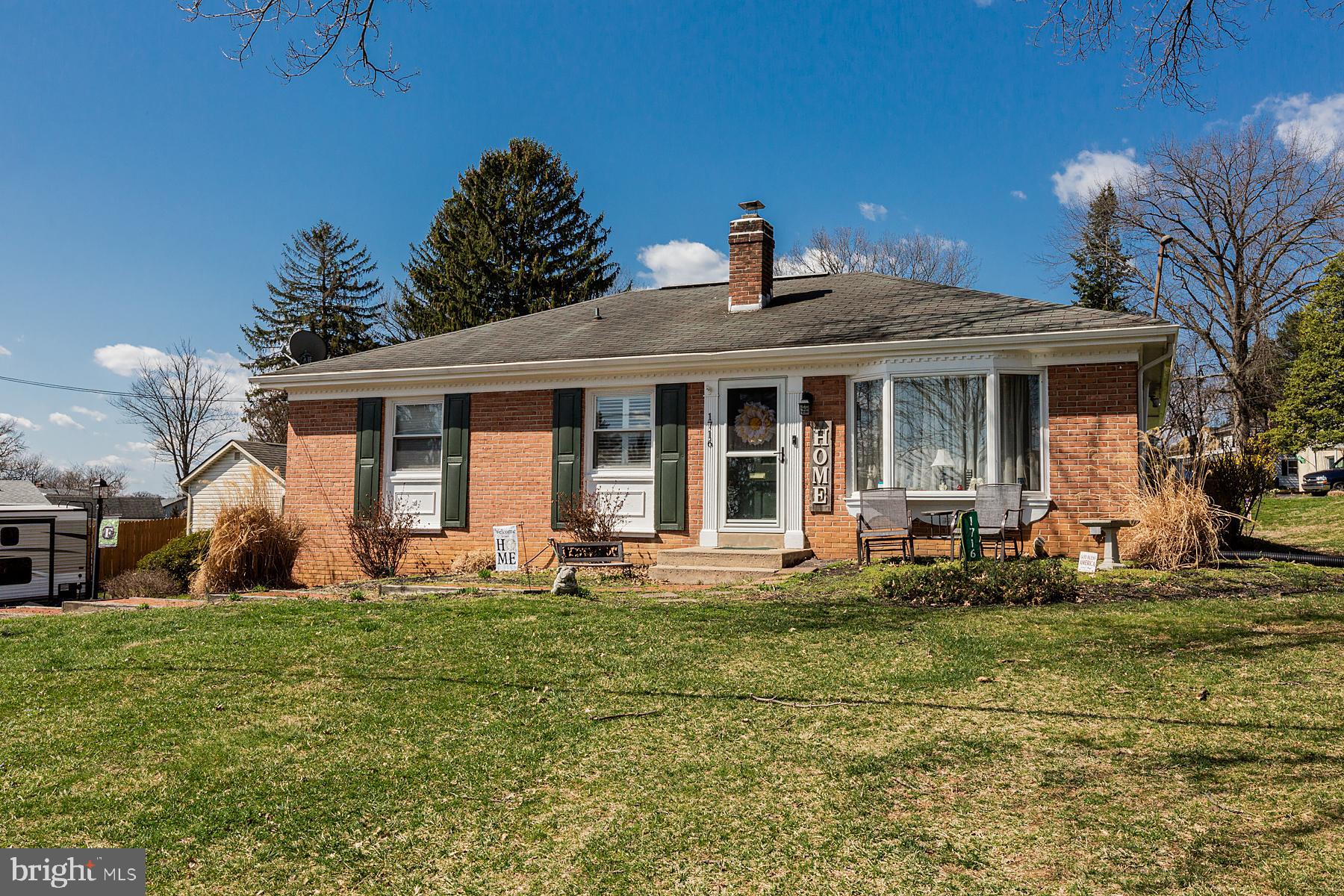 a front view of a house with a yard garden and outdoor seating