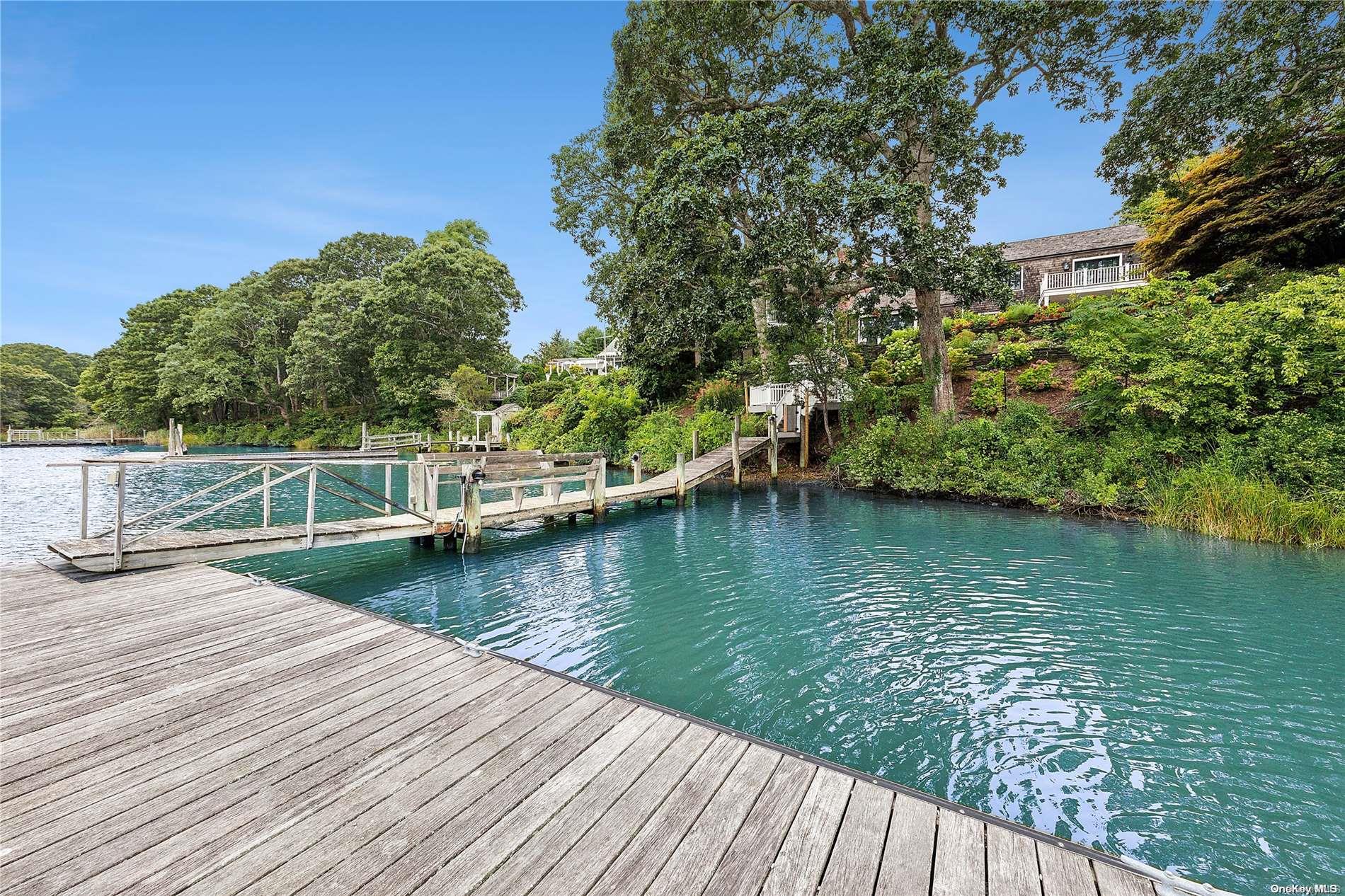 a view of a wooden deck and lake with trees in the background