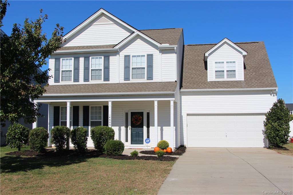 a front view of a house with a garden and plants