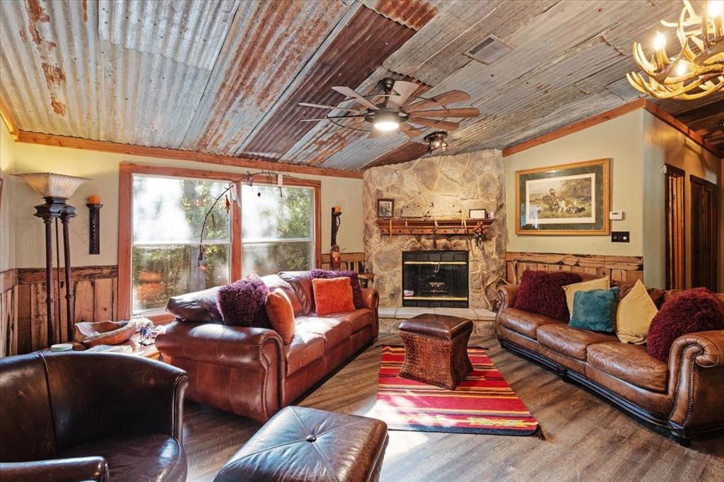 a living room with furniture a flat screen tv and a floor to ceiling window