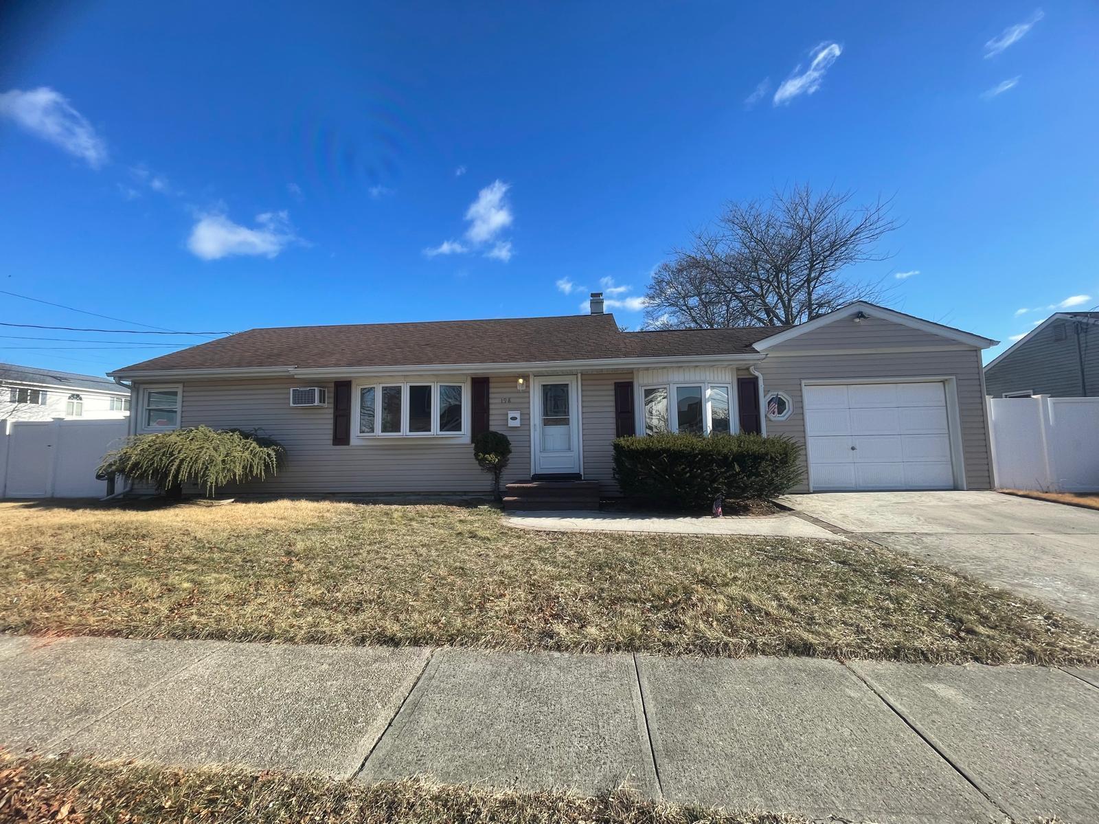 Ranch-style home with a garage and a front lawn