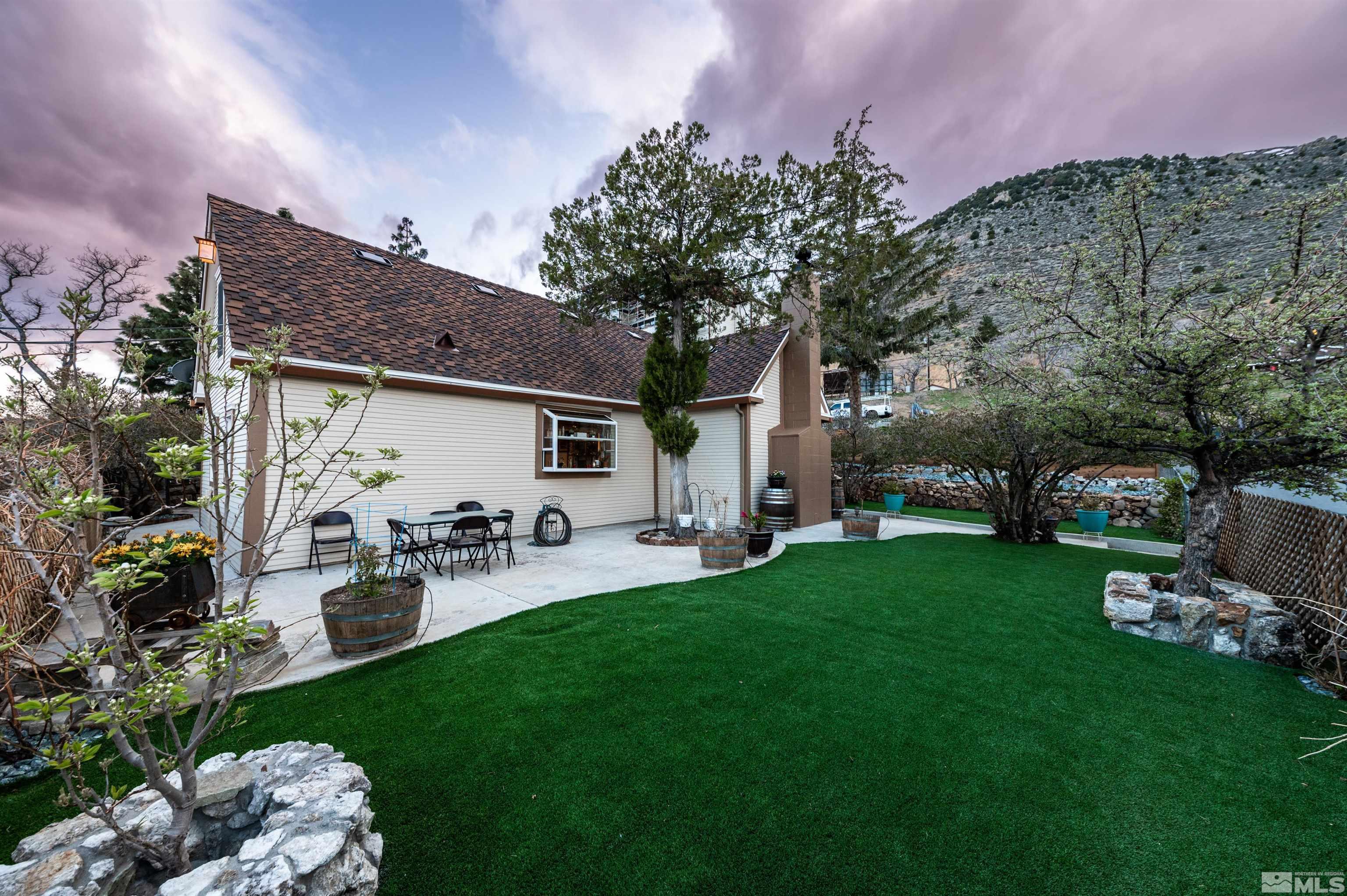 a front view of a house with garden and sitting area