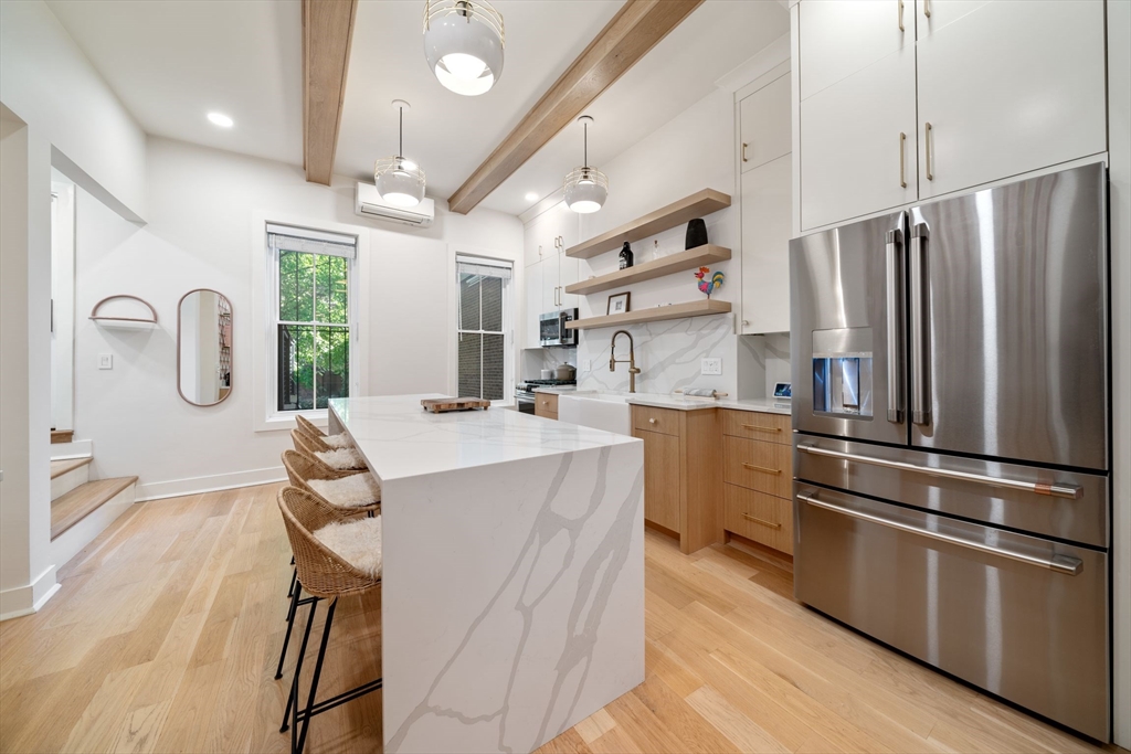 a kitchen with kitchen island a counter top space a sink stainless steel appliances and cabinets