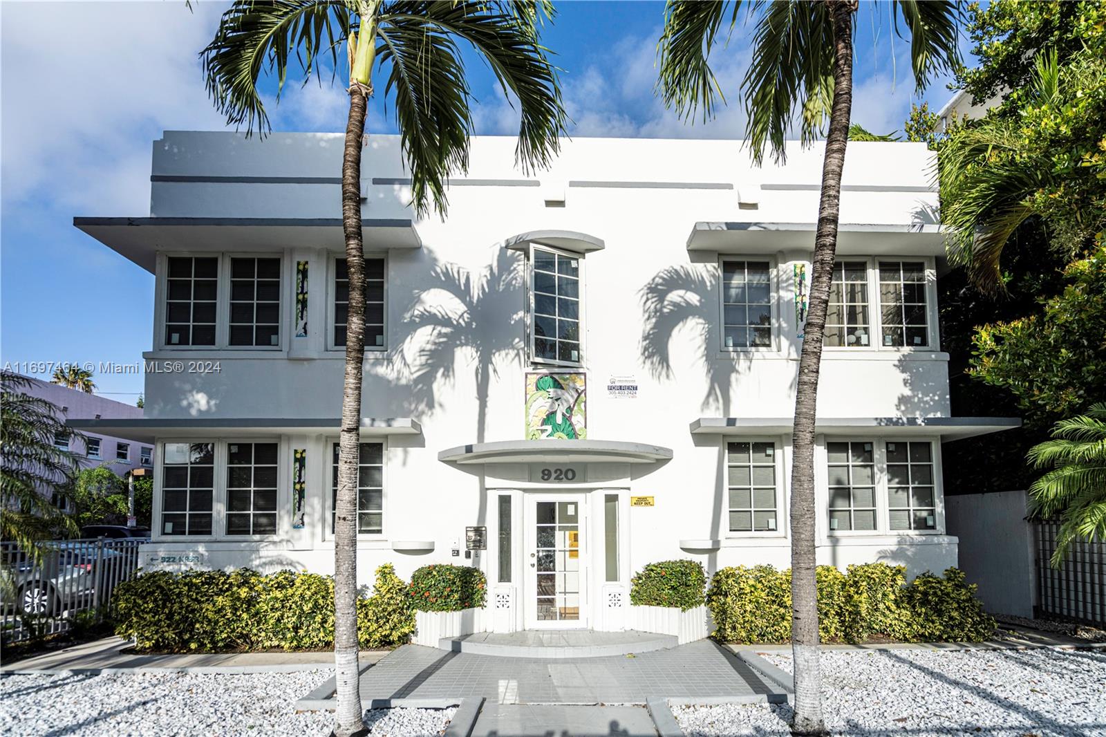 a front view of a house with a palm tree