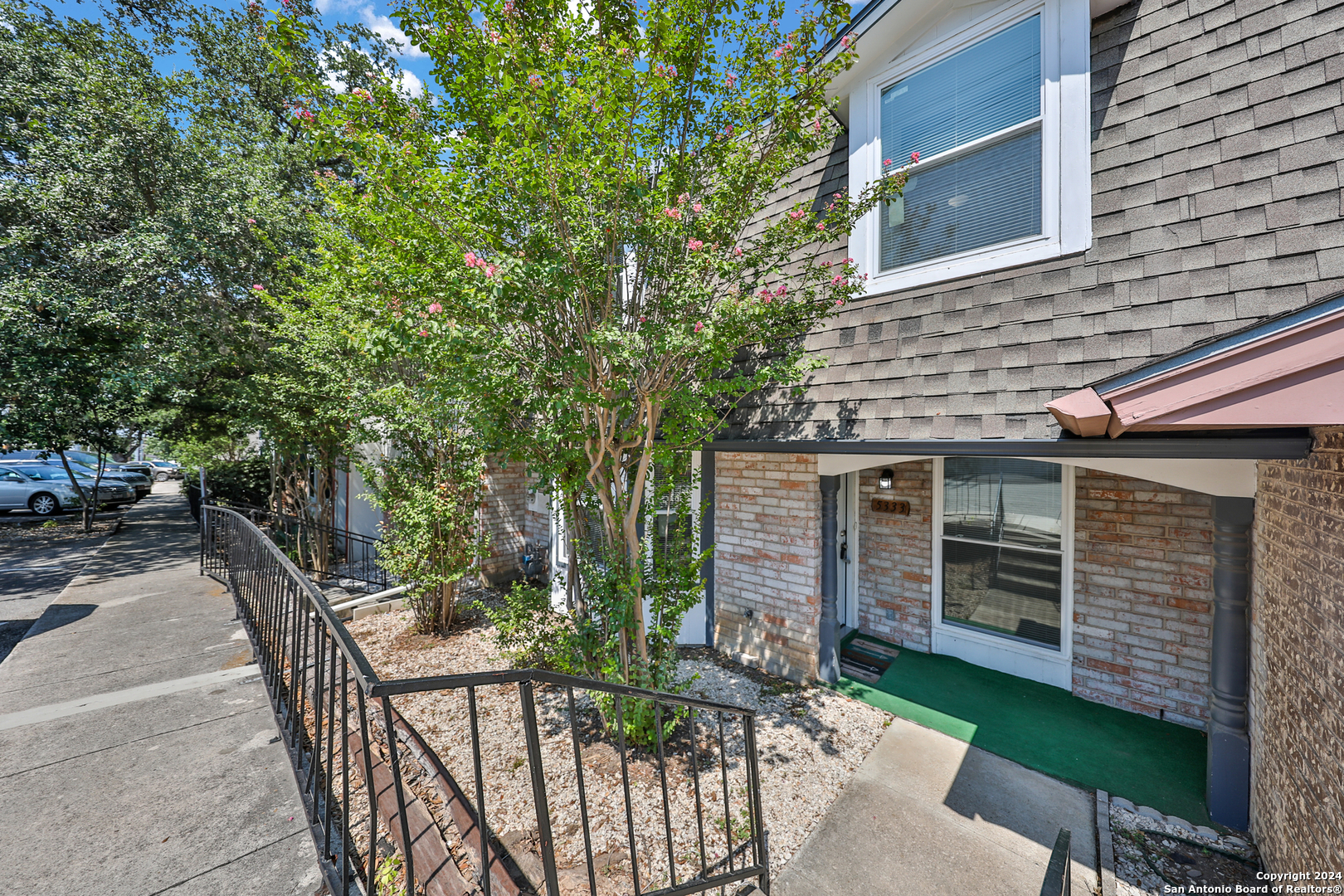 a view of house with patio outdoor seating and covered with trees