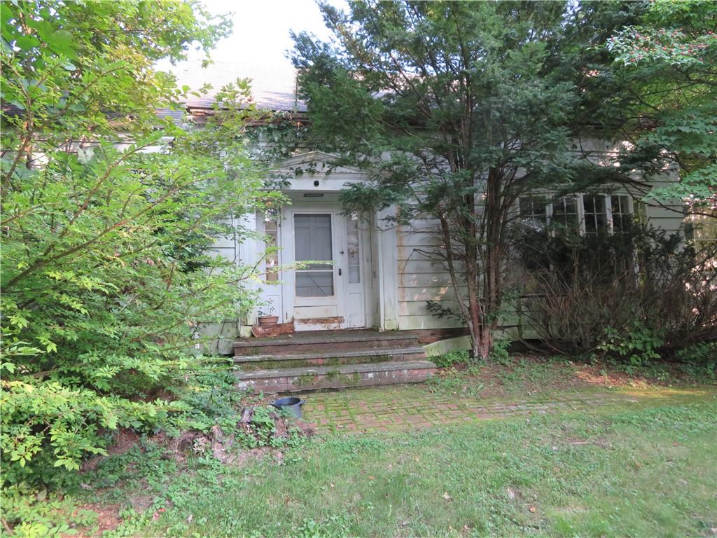 a view of house with a yard and a large tree