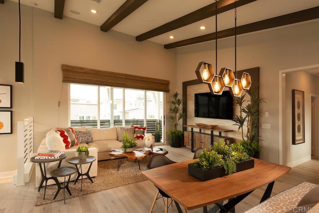 a living room with furniture a dining table and a potted plant