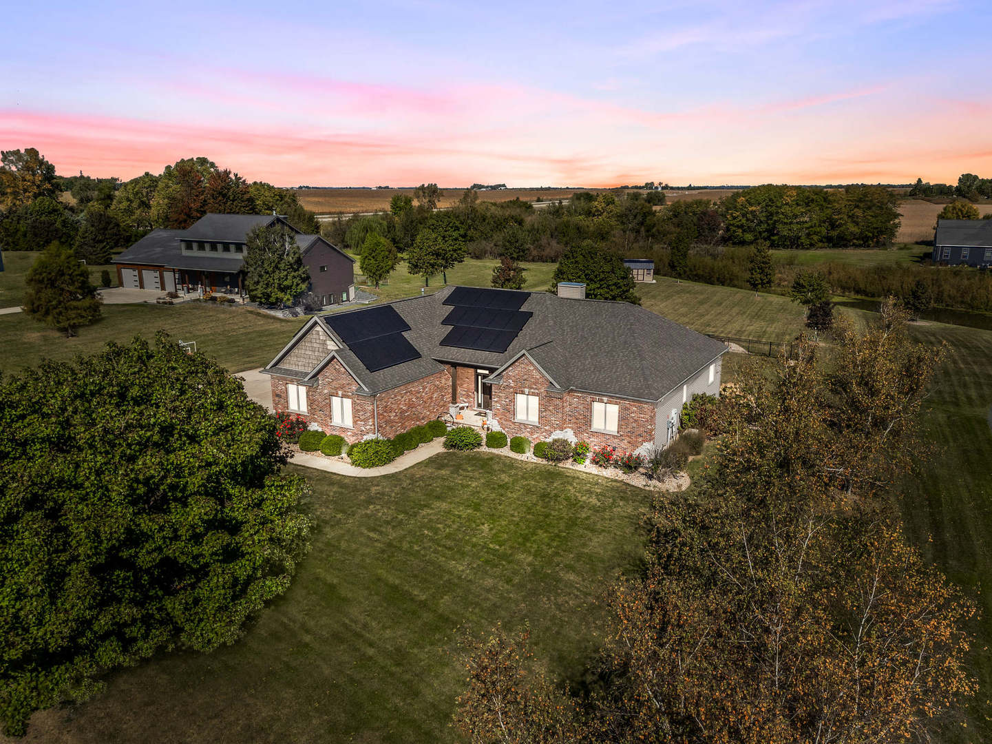 an aerial view of residential houses with outdoor space and trees