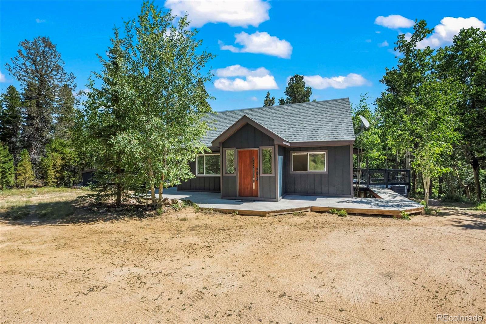 a view of a house with a yard and large tree