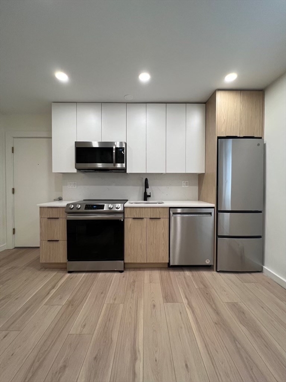 a kitchen with a refrigerator and a stove top oven