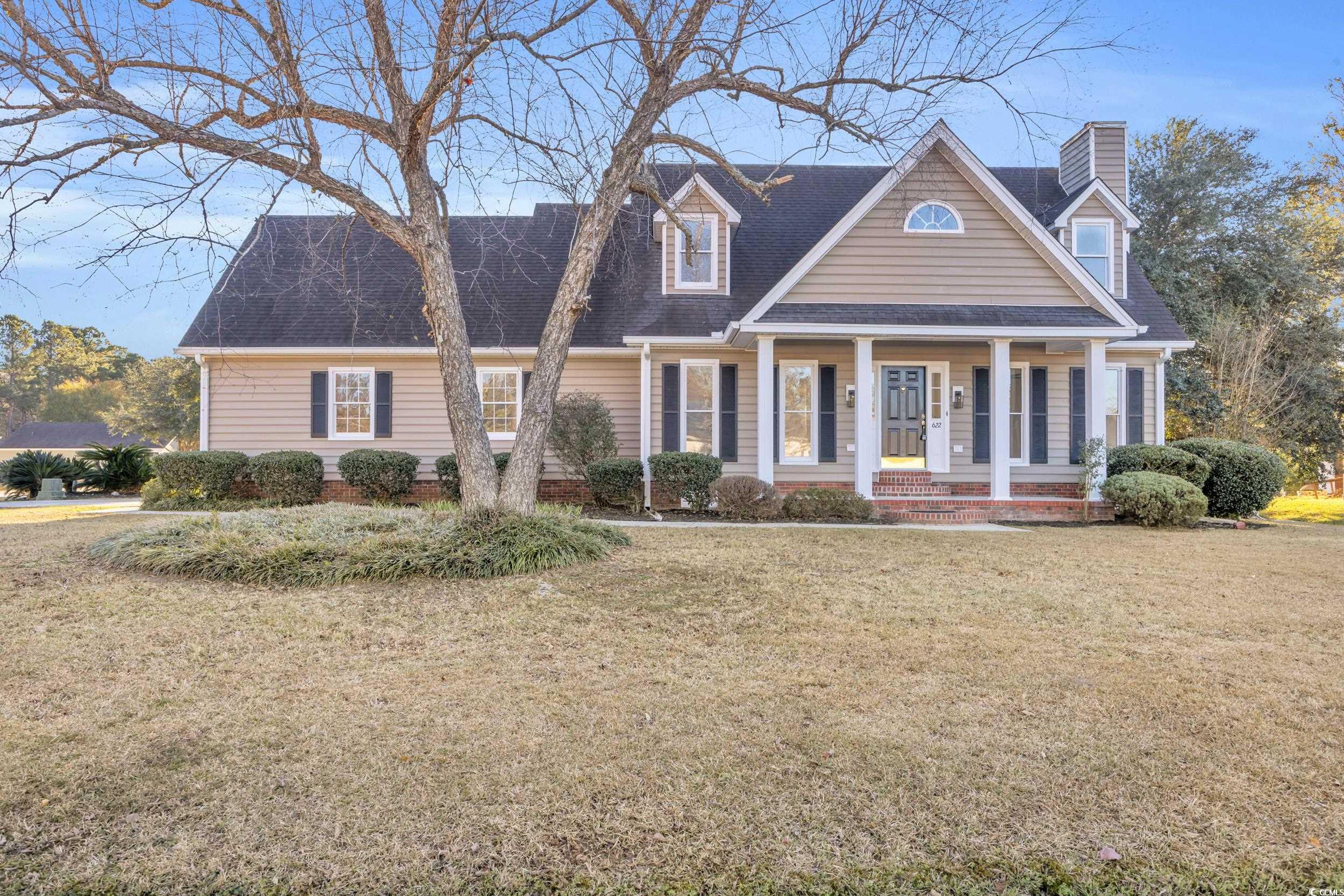 Cape cod home with a front lawn and covered porch