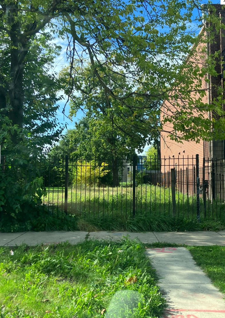 a view of backyard with swimming pool and green space