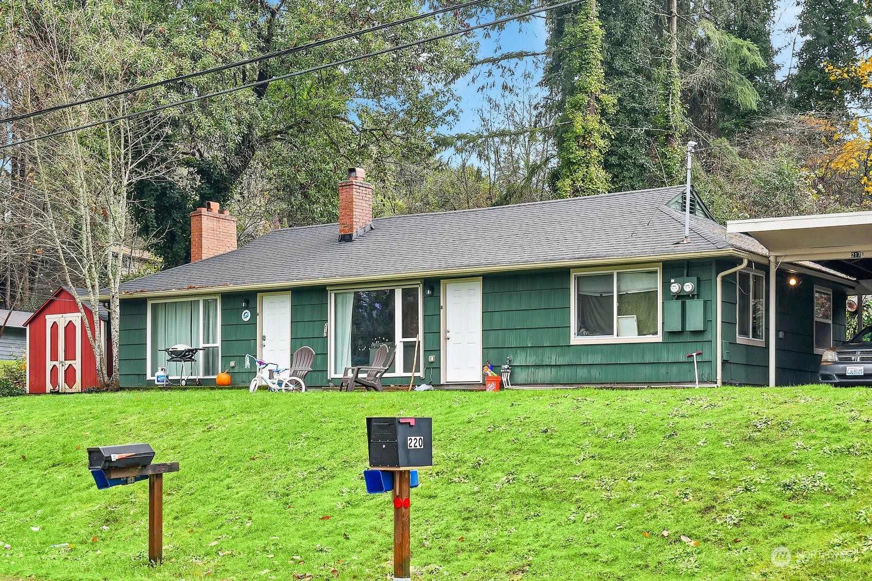 a front view of a house with a yard and trees