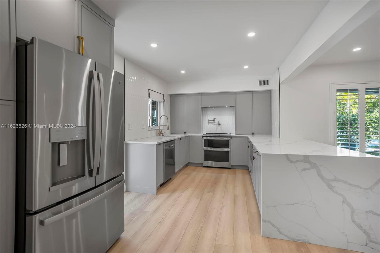 a kitchen with white cabinets and stainless steel appliances