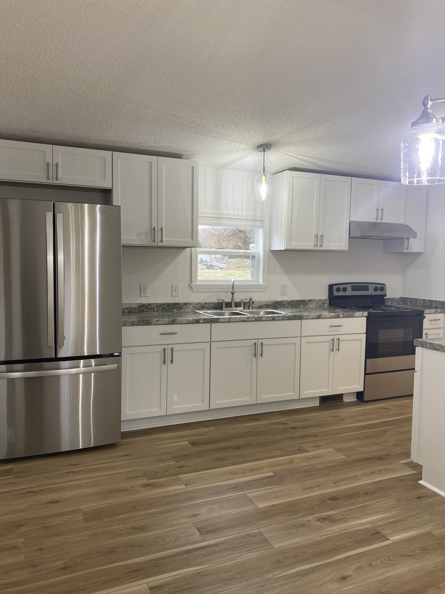 a kitchen with granite countertop white cabinets and stainless steel appliances