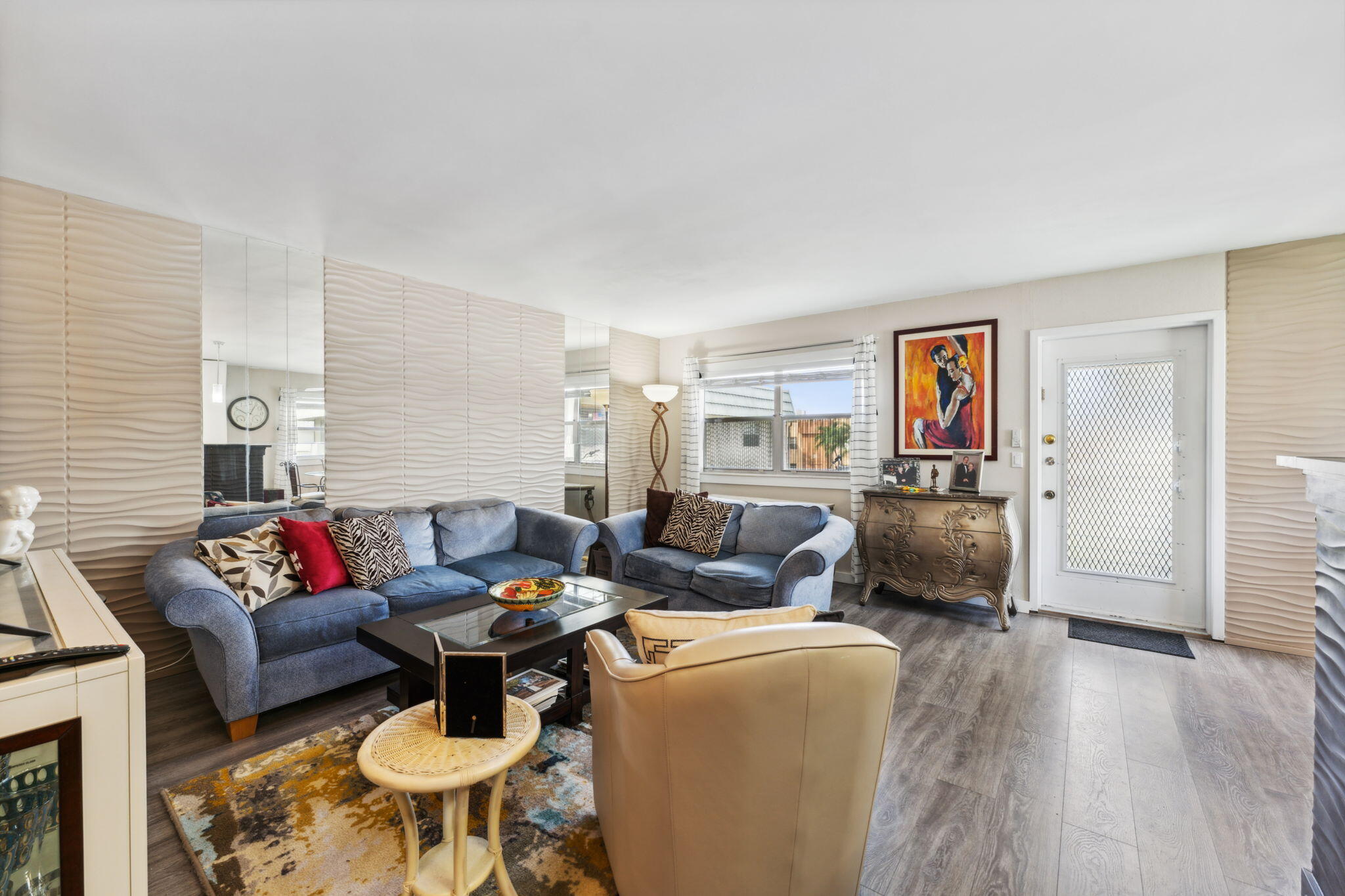 a living room with furniture and a wooden floor