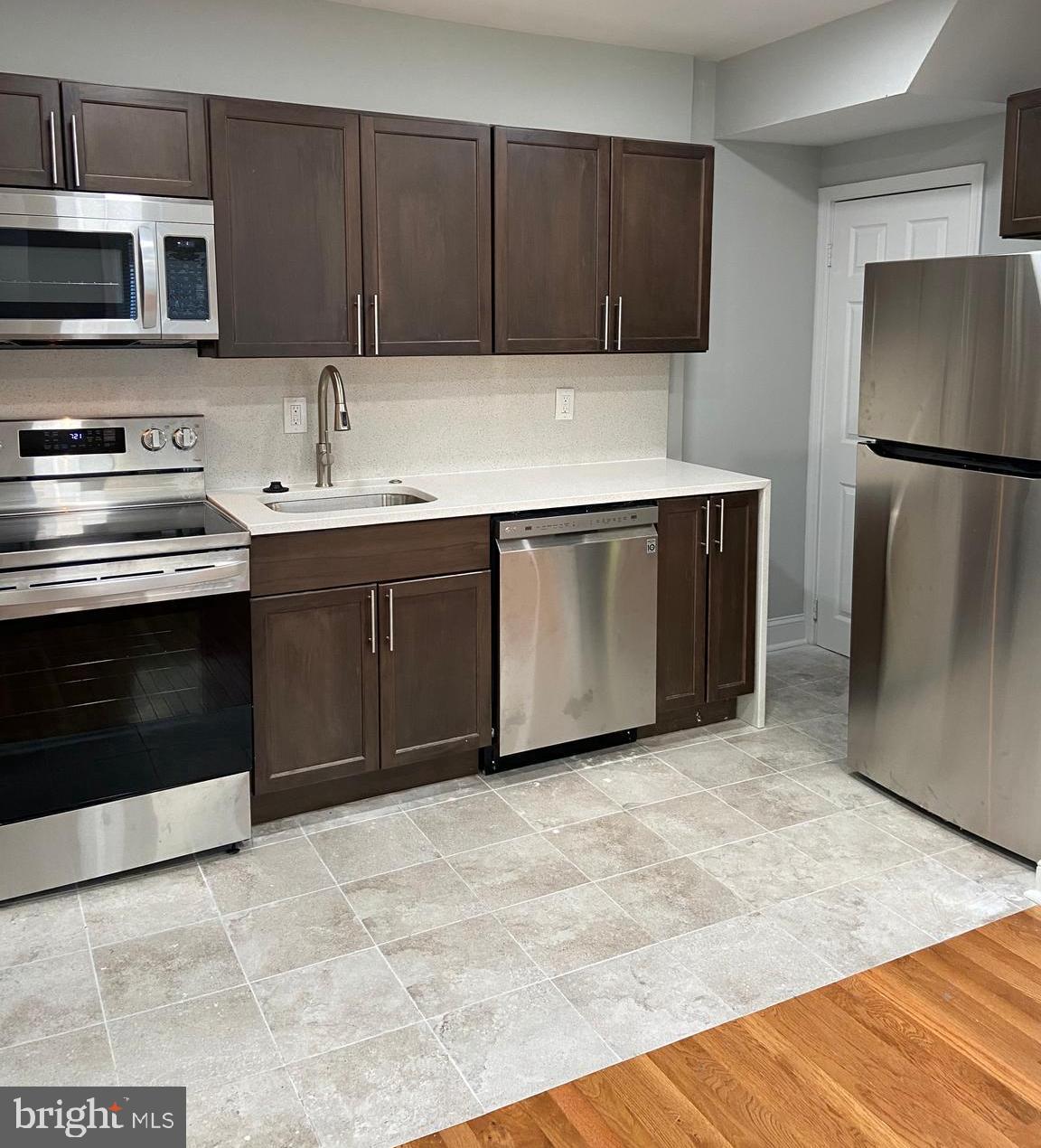 a kitchen with stainless steel appliances granite countertop a refrigerator and a sink