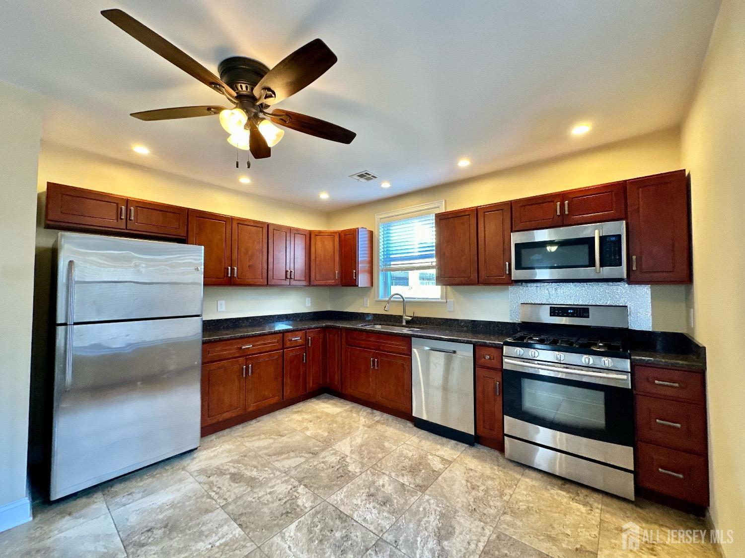 a kitchen with stainless steel appliances granite countertop a stove and a refrigerator