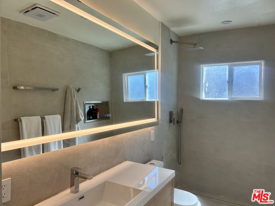 a bathroom with a sink a toilet and a mirror