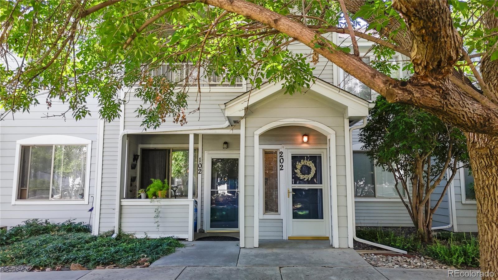 a front view of a house with a tree