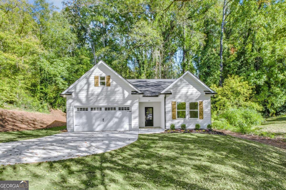 a front view of a house with a yard and trees