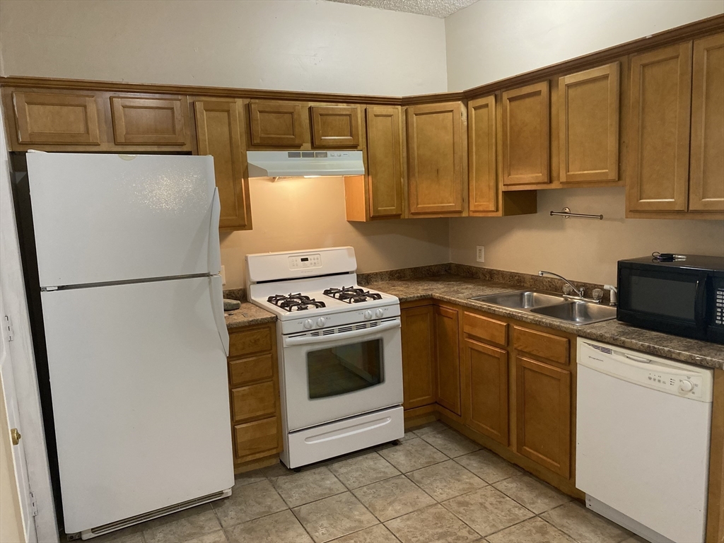 a kitchen with a refrigerator sink and cabinets