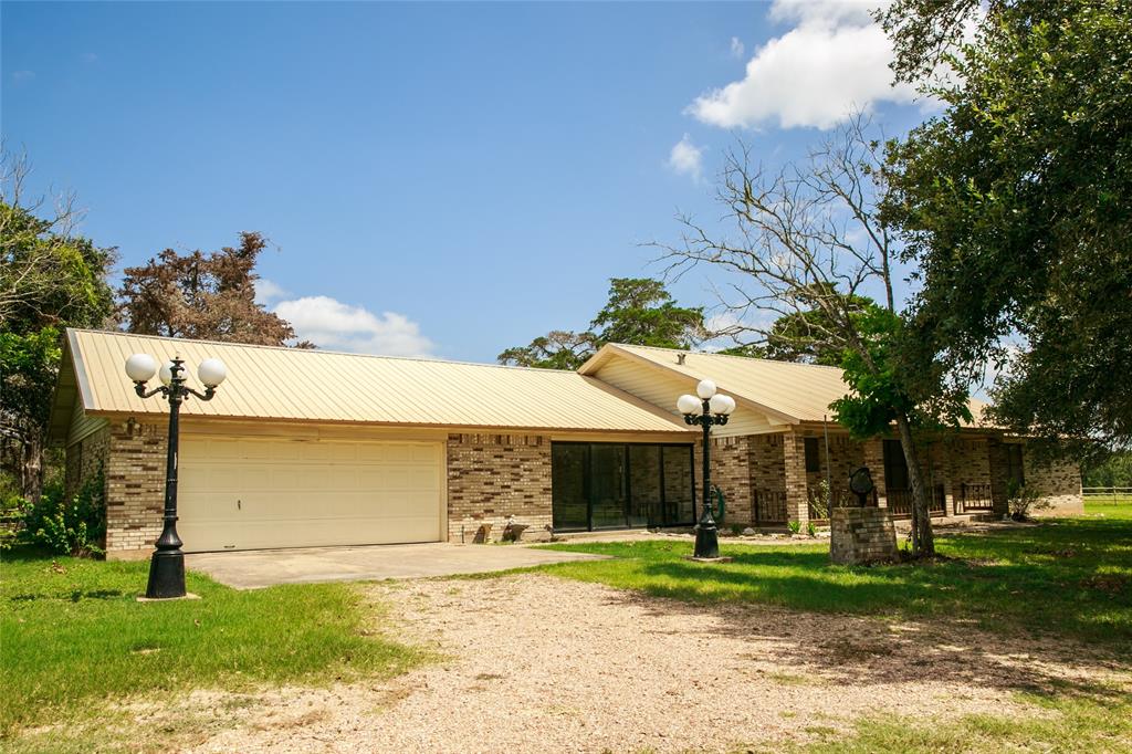 a front view of a house with a garden and trees