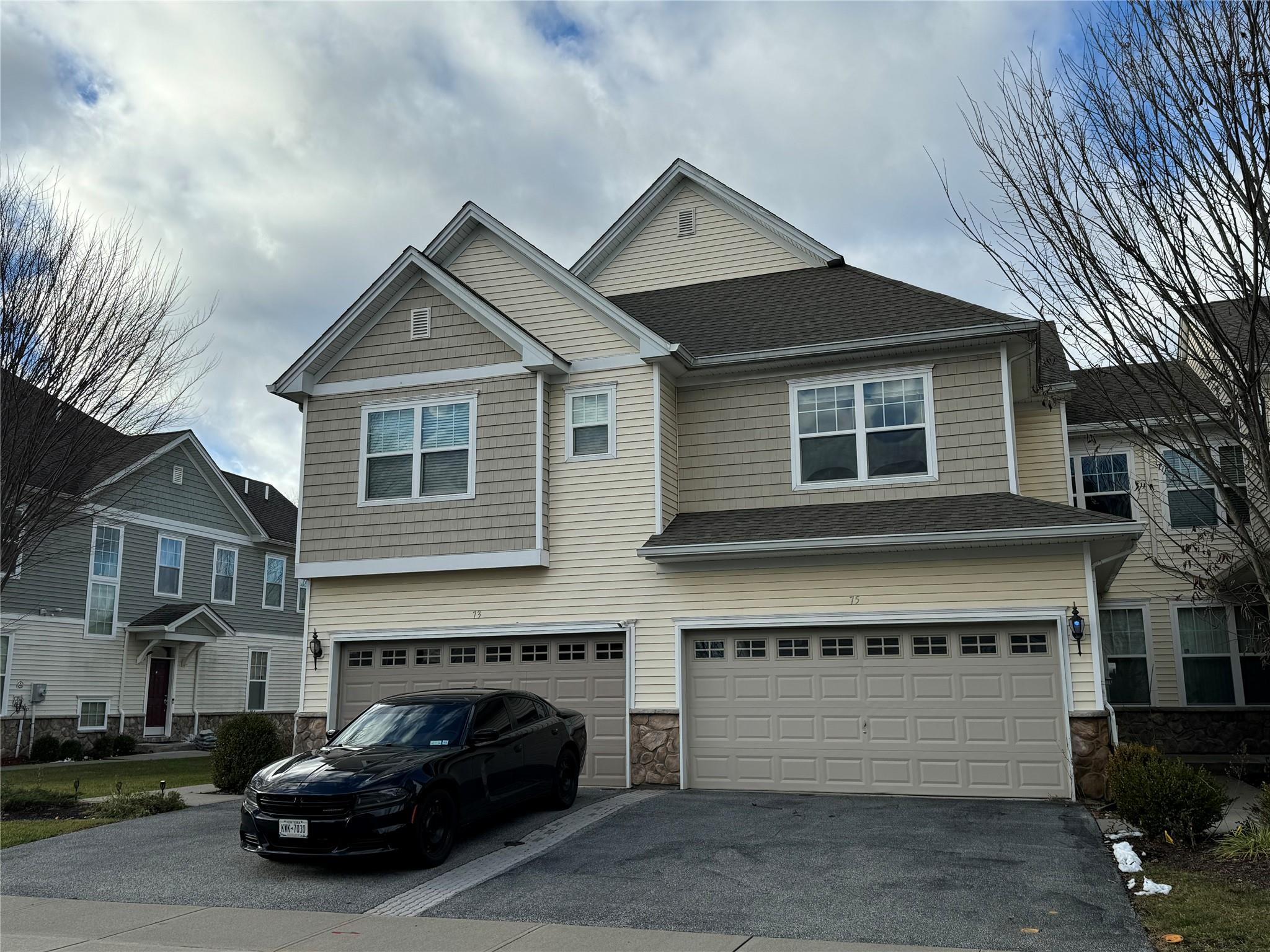 a front view of a house with a parking space