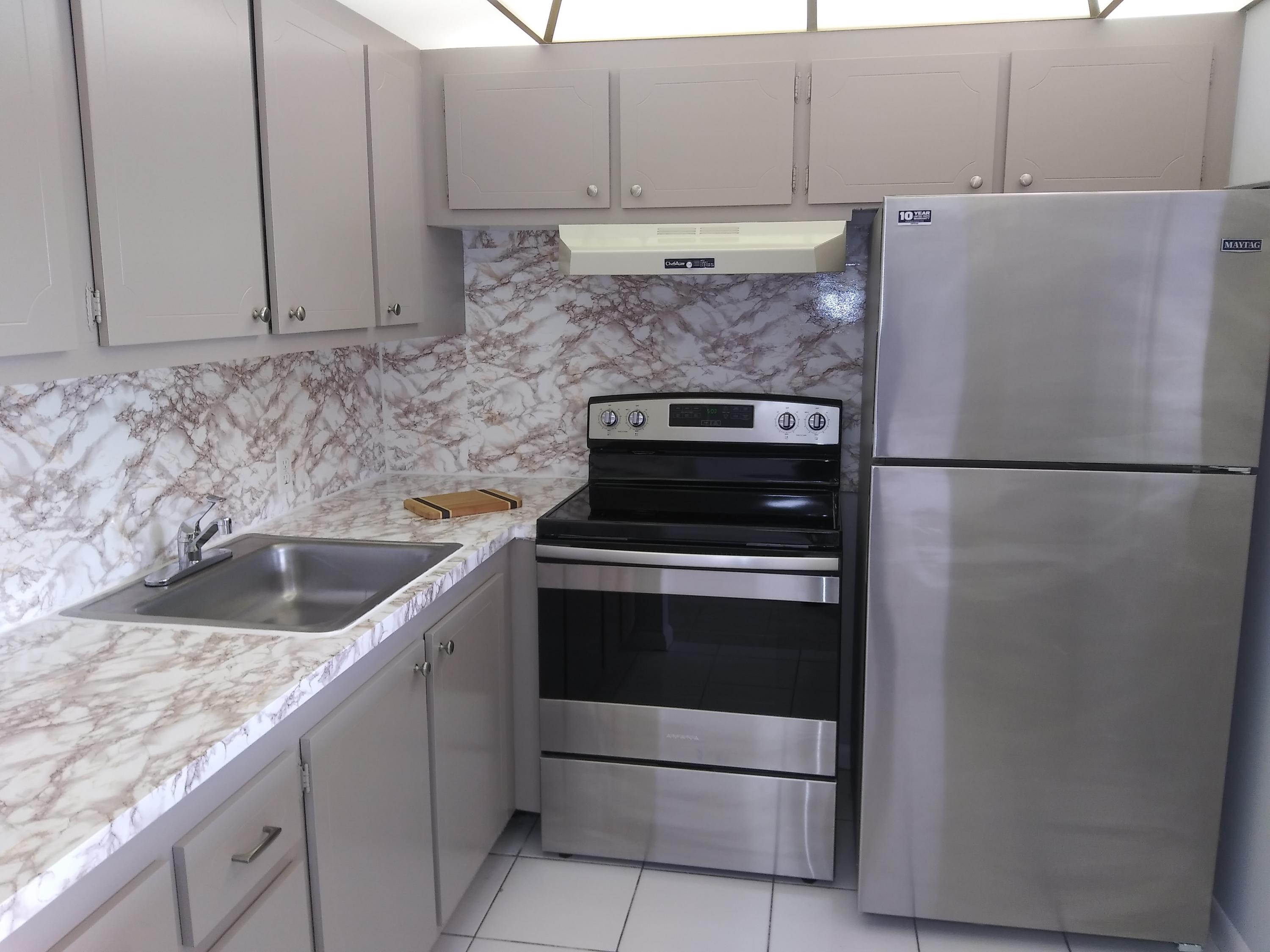 a kitchen with cabinets and white stainless steel appliances