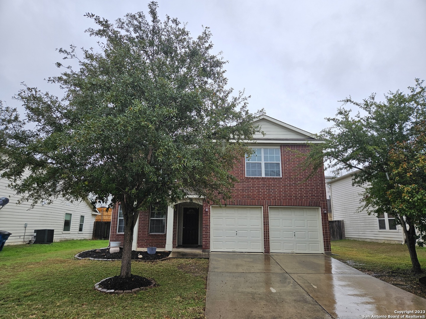 a front view of a house with a tree