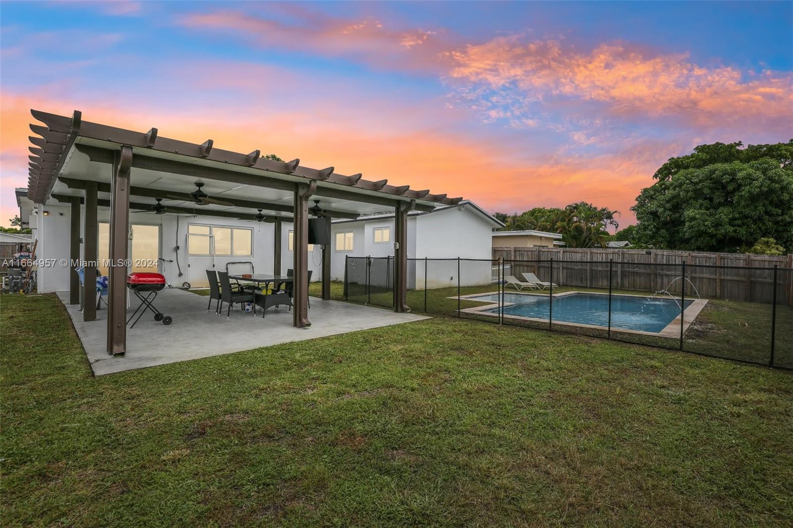 a view of a house with backyard and sitting area