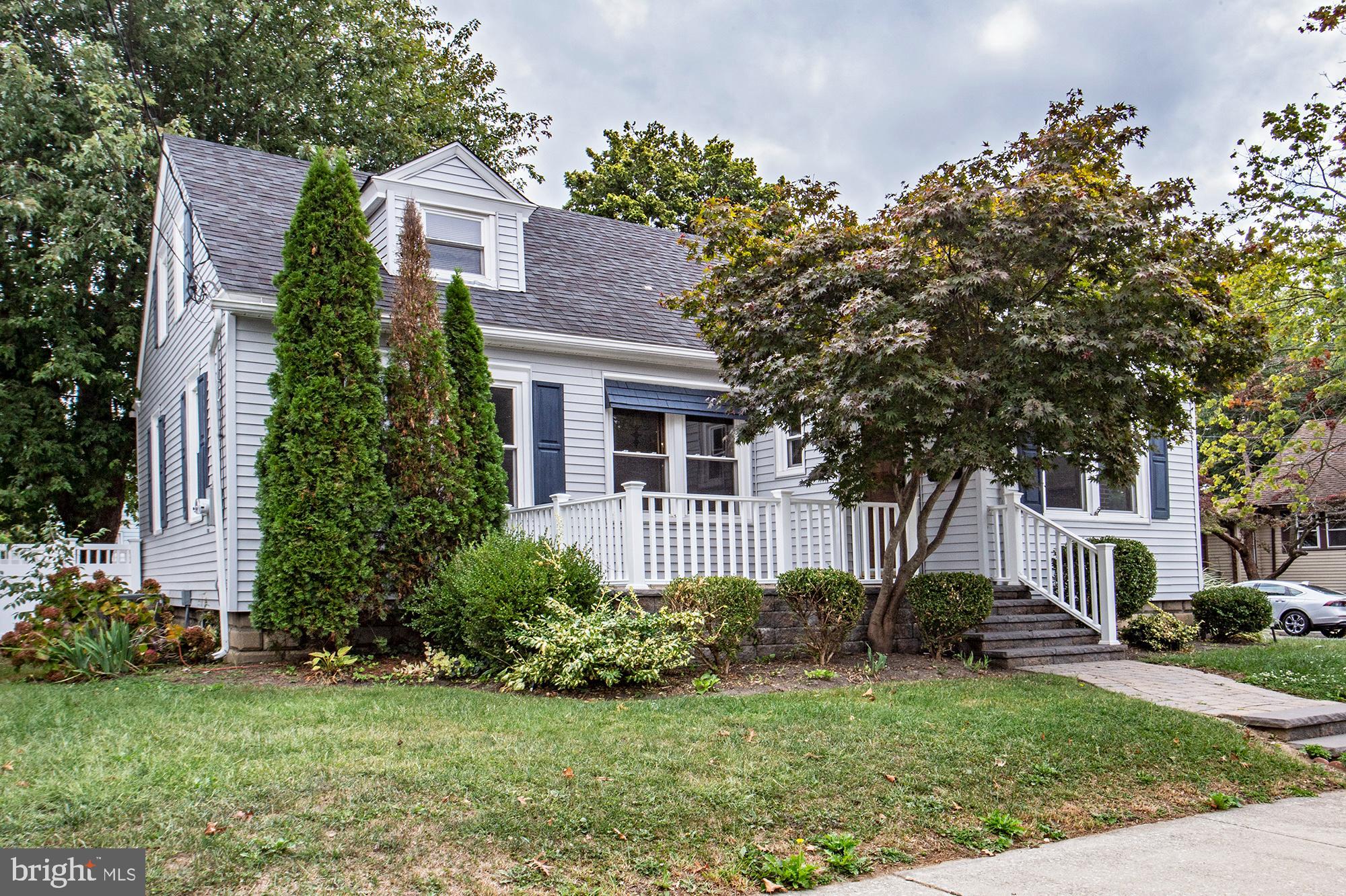 a front view of a house with a yard and trees